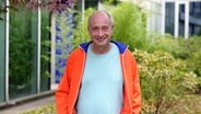 Der Comedian Alfons trägt eine orange Trainingsjacke © NDR 90,3 Foto: Lydia Strang