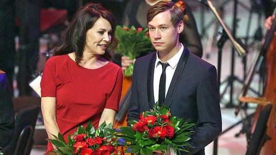 Die Schauspielerin Iris Berben (l) und Schauspieler David Kross (r) stehen am 23.05.2013 zum Festakt anlässlich des 150. Geburtstages der SPD im Gewandhaus in Leipzig (Sachsen) mit Blumen auf der Bühne. © dpa Foto: Kay Nietfeld