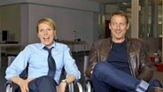 Franziska Weisz und Wotan-Wilke Möhring sitzen bei Dreharbeiten zur Tatort-Folge "Himmelfahrt" nebeneinander in Stühlen. © NDR 