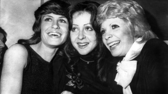 Vicky Leandros (Mitte) freut sich am 26. März 1972 in Edinburgh über ihren Sieg beim Grand Prix Eurovision de la Chanson, zusammen mit Severine (rechts) aus Monaco, der Siegerin von 1971, und der deutschen Mary Roos (links), die den dritten Platz errang. © Picture-Alliance / dpa 