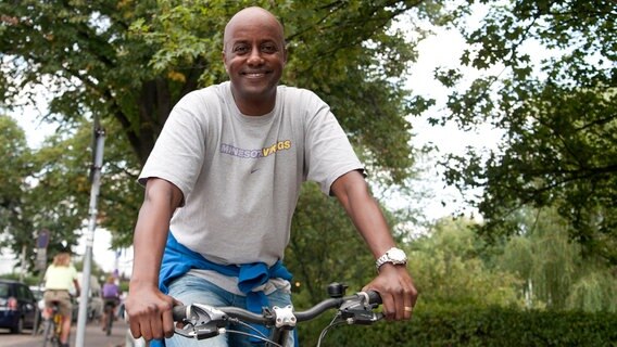 NDR Moderator Yared Dibaba auf einem Fahrrad. © NDR Foto: Claudia Timman