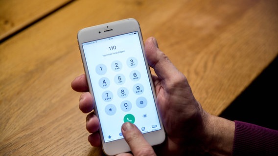 Eine ältere Person hält ihr Handy in der Hand und wählt die Rufnummer 110 der Polizei. © imago images Foto: Fotostand / K. Schmitt