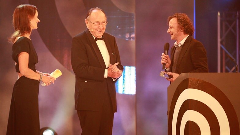 Hans-Dietrich Genscher verleiht den Preis für die "Beste Reportage" an Jens Schellhass (re., Nordwestradio) am 17. September 2010 in Hamburg. Ganz links: Moderatorin Katrin Müller-Hohenstein. © NDR Foto: Marco Maas
