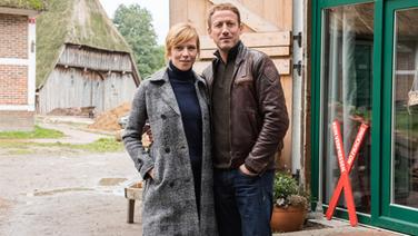 Die Schauspieler Franzsika Weisz (links) und Wotan Wilke Möhring stehen am 19. Oktober 2016 in Hamburg während der Dreharbeiten zum Tatort "Böser Boden" auf einem Bauernhof. © dpa - Bildfunk Foto: Daniel Bockwoldt/dpa