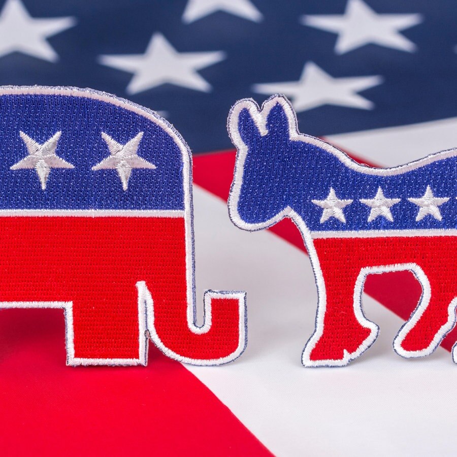 USa Flagge Stars and Stripes mit dem Demokraten Esel-Logo und dem Republikaner Elefanten-Logo © mauritius images / Marcus Harrison - geopolitics / Alamy Foto: All mauritius images