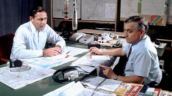 Egon Schätzle und Alfred Max Dörfler sitzen sich am Schreibtisch im NDR Verkehrsstudio gegenüber © NDR/Annemarie Aldag 