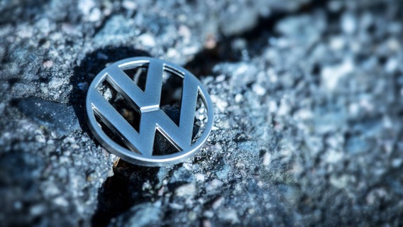 Ein VW Zeichen liegt auf einem Riss auf der Straße. © Christian Ohde Foto: Christian Ohde
