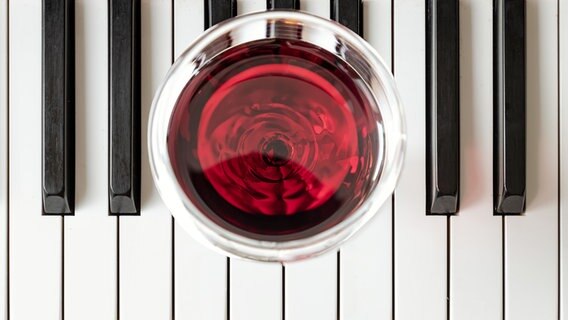 Ein Glas Rotwein auf den Tsten eines Klaviers. © panthermedia/tosirikul Foto: tosirikul