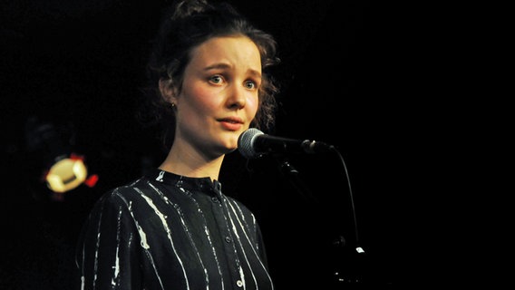 Anni Greve steht auf einer Bühne vor einem Mikrofon. © Björn Högsdal Foto: Björn Högsdal