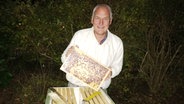 Andreas Busch steht vor seinem Bienenstock. © NDR Foto: Iris Guhl