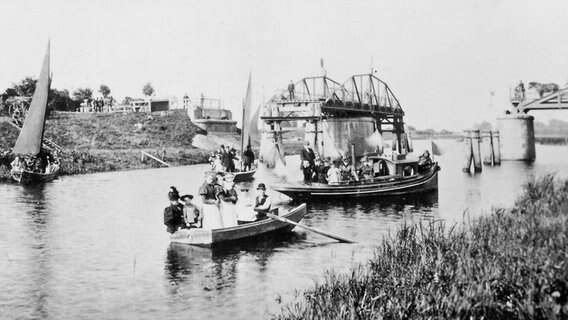 Historisches Foto der Eröffnungsfeier der Klevendeicher Drehbrücke im Sommer 1884. Boote fahren durch die geöffnete Brücke. © Fotosammlung der Gemeinde Haselau 