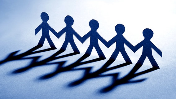 Ein Scherenschnitt von fünf Personen, die sich an den Händen halten. © fotolia Foto: lily