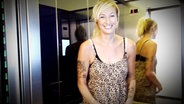 Die Moderatorin Christina Gronwald steht lächelnd in einem Fahrstuhl. © NDR 
