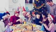 Familienmitglieder hantieren mit ihren Smartphones am gedeckten Weihnachtstisch herum. © fotolia Foto: SJackF