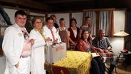 Eine teilweise als Ärzte verkleidete Gruppe Schauspieler steht in einem Wohnzimmer. © NDR Foto: Karin Haug