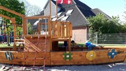 Ein großes Holzschiff auf einem Spielplatz mit kletternden Kindern. © NDR Foto: Karin Haug
