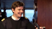 Fährkapitän und Musiker Jan Faltings steht auf seinem Schiff. © NDR 
