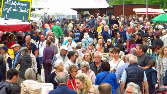 Auf dem Gottorfer Landmarkt laufen zahlreiche Menschen an Ständen vorbei. © NDR Foto: Peer-Axel Kroeske