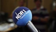 Ein NDR 1 Welle Nord Mikrofon vor unscharfen Hintergrund © NDR Foto: Oke Jens