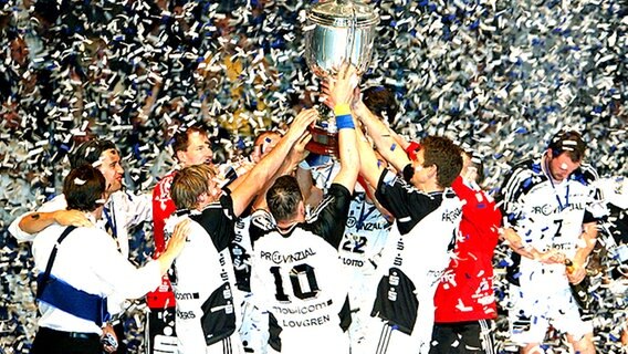 Die Spieler vom THW Kiel jubeln mit dem Pokal nach dem Sieg der Handball Champions League 2007. © picture-alliance/dpa 