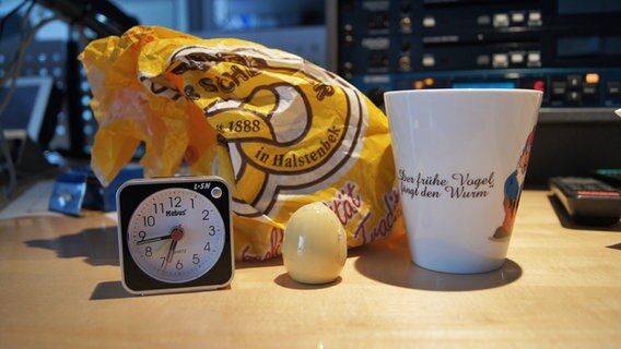 Ein Wecker, Brot und Salz und ein Kaffeebecher © NDR Foto: Juliane Thomas