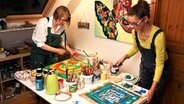 Zwei Frauen stehen in einem Atelier und malen. © NDR Foto: Lornz Lorenzen