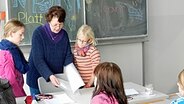 Malene Gottburgsen teilt die neuen plattdeutschen Texte in der Sprachenklasse Kreativ der Regionalschule Niebüll für den sechsten Jahrgang aus © NDR Foto: Ines Barber