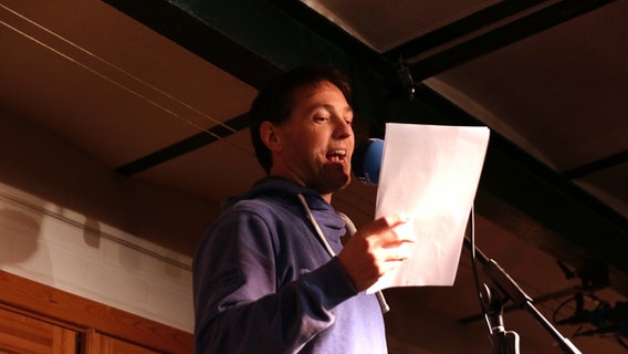 Gerrit Hoss steht auf der Bühne vor einem Mikrofon. © NDR Foto: Lornz Lorenzen