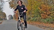 Tommy Alles aus Agethgorst im Kreis Steinburg fährt mit seinem Fahrrad auf der Straße © NDR Foto: Peter Bartelt