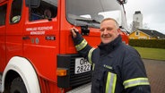 Maik Plöger steht vor einem Löschfahrzeug der Feuerwehr aus Heringsdorf. © NDR Foto: Astrid Wulf