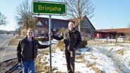 Andreas Wetzel (l.) und Daniel von Petersdorff am Ortsschild von Brinjahe © NDR Foto: Iris Guhl