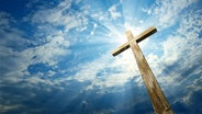 Ein Holzkreuz vor einem wolkigem Himmel. © fotolia Foto: vladischern