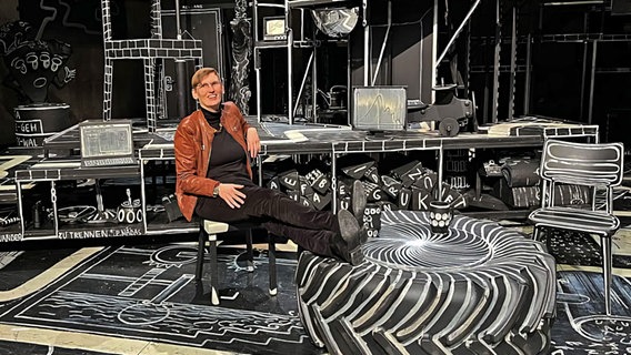 Ein Frau sitzt auf einem Gerüst in einem Theatersaal © NDR Foto: bereitgestellt von Eva von Redecker