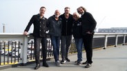 Jan Malte Andresen steht mit der Band Santiano auf einer Brücke. © NDR Foto: Lisa Pandelaki