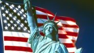 Montage: Freiheitsstatue mit amerikanischer Flagge © picture-alliance / Bildagentur Huber 