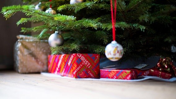 Unter dem geschmückten Weihnachtsbaum liegen Geschenke.  Foto: Wedel/Kirchner-Media