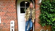 Julia Nissen steht in der Eingangstür zu einem Klinkerhaus. © NDR Foto: Ines Barber