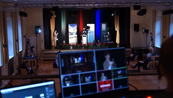 Moderatorin Elin Hinrichsen (l.) und zwei weitere Personen befinden sich auf der Bühne  der Nordseeakademie in Leck während der Veranstaltung Ferteel iinjesen. © NDR Foto: Lornz Lorenzen