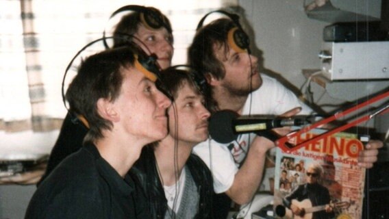 Ein altes Foto zeigt vier junge Leute vor Mikros in einem Radiostudio. © NDR 