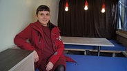 Sozialpädagogin Miriam Peters sitzt in einer roten Jacke an einem Tisch in einem Van. © NDR Foto: Astrid Wulf