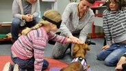 Ein Mädchen streichelt mit verbundenen Augen einen Hund. © NDR Foto: Rebekka Mehrholz