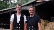 Marco Reimers (rechts) und Benny Lorenzen stehen in Arbeitskluft vor einem Stall. © NDR Foto: Ines Barber