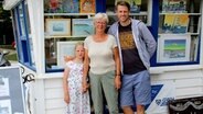 Gudrun Lahrsen (Mitte), Inger Lütjohann mit Enkelin Mia, Arno Draschba vor dem Kunstkiosk an der Promenade von Möltenort. © NDR Foto: Andrea Ring