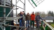 Eine Gruppe steht auf einem Gerüst an der Mühle Anna in Rieseby. © NDR Foto: Ines Barber