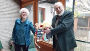 Marianne Ehlers und Wilhelm Nehlsen stehen nebeneinander und halten jeweils eine Handpuppe. © NDR Foto: Lina Bande