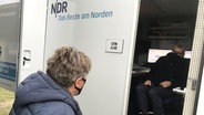 Nick Wilder unterhält sich mit einem Mann, der in einem Wagen des NDR sitzt.  Foto: Lornz Lorenzen
