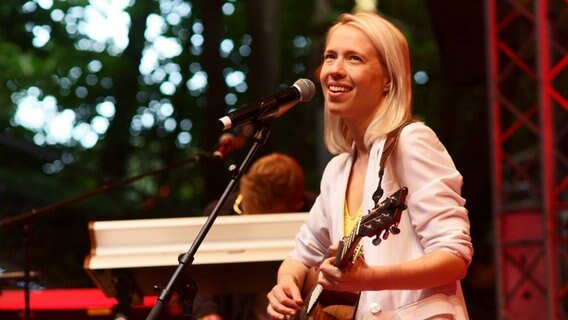 Norma Schulz steht mit ihrer Gitarre auf der Bühne und singt. © NDR Foto: Lornz Lorenzen