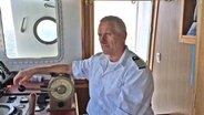 Kapitän Heinrich von Holdt in der Steuerkabine eines Schiffs © NDR Foto: Jan Altmann