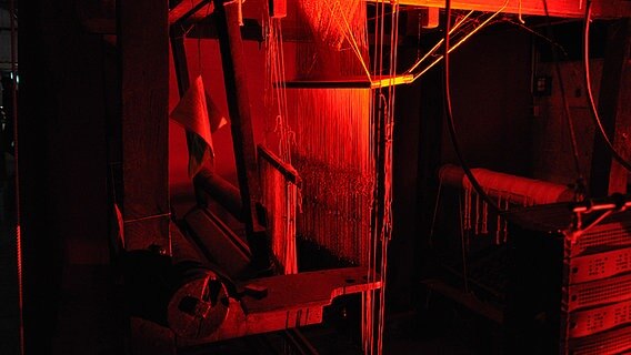 Ein alter Tuchmacherwebstuhl steht in rotem Licht  Foto: Maja Bahtijarevic