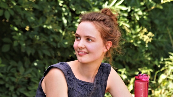 Anni Greve sitzt im Grünen und blickt lächelnd zur Seite. © NDR Foto: Lornz Lorenzen
